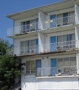 There is more than just the one damaged balcony – much of the building probably doesn’t meet building or safety codes.  Why hasn’t the city done something about this situation?  Because it houses homeless people?  Because the Region is renting the building?