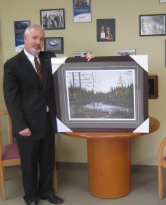 Scott Stewart, one of the city's two General Managers poses with an award he was given for leadership at the inter-municipal level.