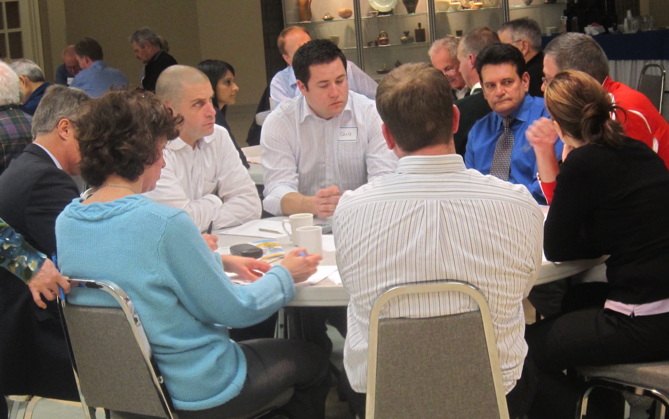 Citizens gather for budget discussions. This meeting involved a number of city firemen who were attentively listened to by Councillor Craven, on the right in the blue shirt.
