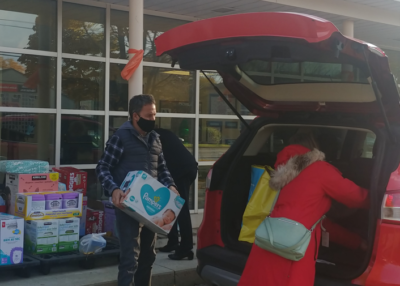 Councillor Galbraith loading Huggies into a vehicle.