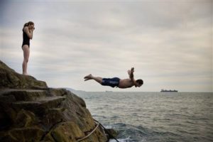 Jonathan Cairns dives at Sandycove in Dublin, while Rachel Armstrong awaits her turn December 25, 2008. You Witness News/Fiona Brophy