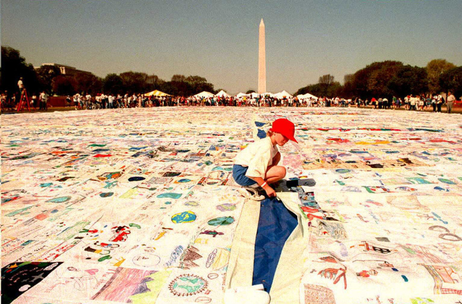 A child with "Kids for a Clean Environment" helps