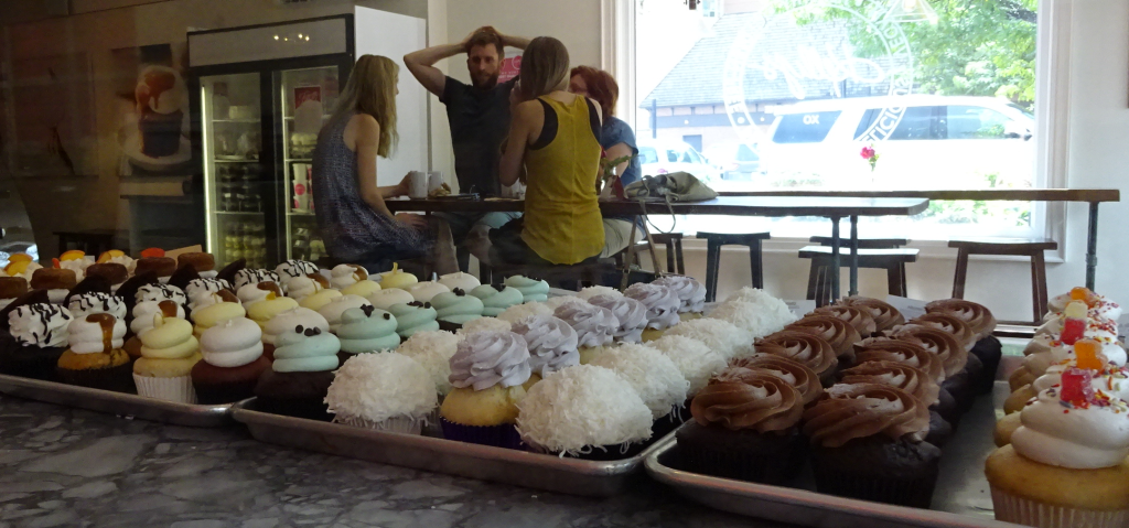 Kellys - counter of cup cakes with people